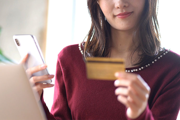 クレジットカードとスマホを持つ女性