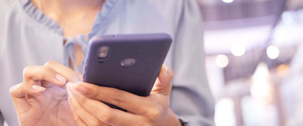 街でスマートフォンを操作する女性の手元の写真