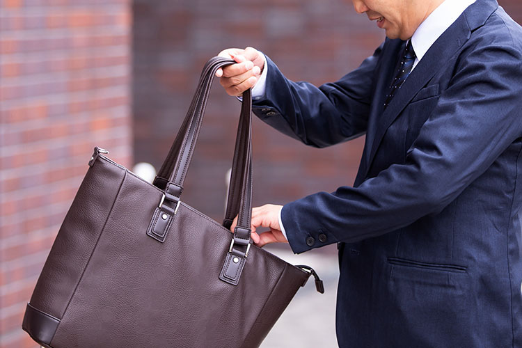 トートバッグを手に持つスーツ姿の男性