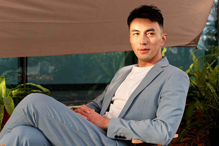 スーツを着てソファに寄りかかる男性の写真